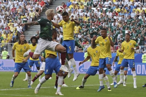 Brazil's Casemiro, top right, heads the ball away next to Mexico's Carlos Salcedo, top left, during the round of 16 match between Brazil and Mexico at the 2018 soccer World Cup in the Samara Arena, in Samara, Russia, Monday, July 2, 2018. (AP Photo/Thanassis Stavrakis)