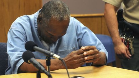 FILE - In this July 20, 2017, file photo, former NFL football star O.J. Simpson reacts after learning he was granted parole at Lovelock Correctional Center in Lovelock, Nev. Simpson was convicted in 2008 of enlisting some men he barely knew, including two who had guns, to retrieve from two sports collectibles sellers some items that Simpson said were stolen from him a decade earlier. A Nevada prison official said early Sunday, Oct. 1, 2017, O.J. Simpson, the former football legend and Hollywood star, has been released from a Nevada prison in Lovelock after serving nine years for armed robbery.  (Jason Bean/The Reno Gazette-Journal via AP, Pool, File)