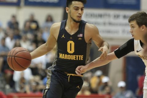 Marquette guard Markus Howard (0) tries to get by Wichita State guard Austin Reaves (12) during the first half of an NCAA college basketball game, Tuesday, Nov. 21, 2017, in Lahaina, Hawaii. (AP Photo/Marco Garcia)