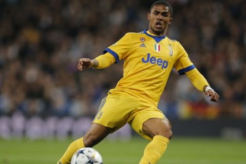 Juventus' Douglas Costa controls the ball during a Champions League quarter-final, 2nd leg soccer match between Real Madrid and Juventus at the Santiago Bernabeu stadium in Madrid, Spain, Wednesday, April 11, 2018. (AP Photo/Paul White)