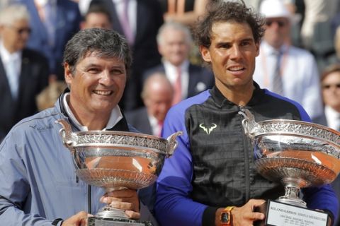 Spain's Rafael Nadal, right, poses with the special Decima cup while his oncle Toni Nadal holds the men's winner cup after the final match of the French Open tennis tournament at the Roland Garros stadium, Sunday, June 11, 2017 in Paris. Nadal has won his record 10th French Open title, beating No. 3 Stan Wawrinka in straight sets (AP Photo/Michel Euler)