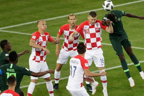 Nigeria players (green) and Croatia players jump for the ball during the group D match between Croatia and Nigeria at the 2018 soccer World Cup in the Kaliningrad Stadium in Kaliningrad, Russia, Saturday, June 16, 2018. (AP Photo/Michael Sohn)