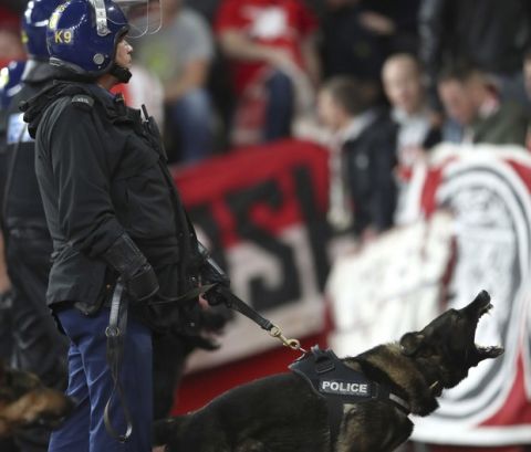 Police with dogs keep watch over FC Koln fans during the Europa League match against Arsenal at the Emirates Stadium, London, Thursday Sept. 14, 2017. Extra police were  sent to the stadium to deal with disorder after thousands of Cologne fans turned up ahead of the match. The game was due to kick off at 8.05pm but was been delayed by an hour in the interest of fan safety after huge crowds of Cologne supporters arrived at the ground. (Nick Potts/PA via AP)