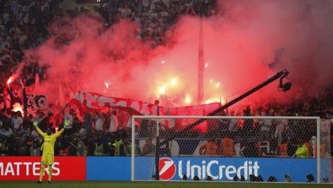 Marseille's goalkeeper Steve Mandanda gestures as fans set off flares during the Europa League Final soccer match between Marseille and Atletico Madrid at the Stade de Lyon in Decines, outside Lyon, France, Wednesday, May 16, 2018. (AP Photo/Francois Mori)