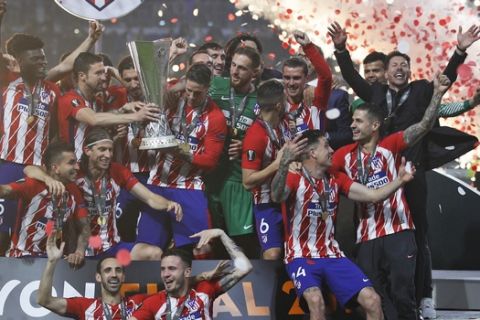 Atletico players celebrate with the trophy after winning the Europa League Final soccer match between Marseille and Atletico Madrid at the Stade de Lyon in Decines, outside Lyon, France, Wednesday, May 16, 2018. (AP Photo/Francois Mori)