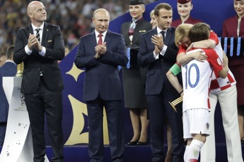 Croatian President Kolinda Grabar-Kitarovic embraces Croatia's Luka Modric after he received the player of the tournament award after the final match between France and Croatia at the 2018 soccer World Cup in the Luzhniki Stadium in Moscow, Russia, Sunday, July 15, 2018. France won the final 4-2. (AP Photo/Matthias Schrader)
