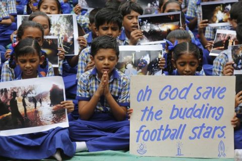 Indian students pray for boys and their soccer coach who have been trapped since June 23, in Mae Sai, Chiang Rai province, northern Thailand, at a school in Ahmadabad, India, Monday, July 9, 2018. Two more ambulances have left the site of a flooded cave in northern Thailand where young members of a soccer team and their 25-year-old coach have been trapped for more than two weeks. (AP Photo/Ajit Solanki)