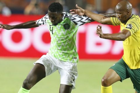 South Africa's Daniel Cardoso, left, and Nigeria's Abdullahi Shehu fight for the ball during the African Cup of Nations s quarterfinal soccer match between Nigeria and South Africa in Cairo International Stadium, Egypt, Wednesday, July 10, 2019 . (AP Photo/Ariel Schalit)