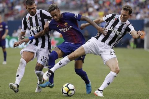 Barcelona's Neymar, center, battles against Juventus' Stefano Sturaro, left, and Stephan Lichtsteiner during the first half of an International Champions Cup soccer match, Saturday, July 22, 2017, at MetLife Stadium in East Rutherford, N.J. (AP Photo/Julio Cortez)