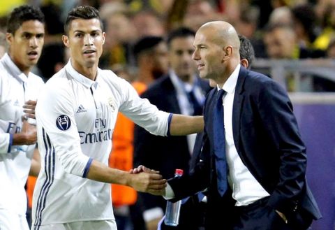 Real Madrid's Cristiano Ronaldo celebrates scoring the opening goal with Real Madrid's head coach Zinedine Zidane during the Champions League group F soccer match between Borussia Dortmund and Real Madrid in Dortmund, Germany, Tuesday, Sept. 27, 2016. (AP Photo/Michael Probst)