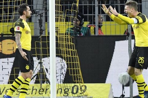 Dortmund's Paco Alcacer, left, celebrates with Dortmund's Lukasz Piszczek, right, after scoring his side's second goal in the last minute during the German Bundesliga soccer match between Borussia Dortmund and SC Freiburg in Dortmund, Germany, Saturday, Dec. 1, 2018. (AP Photo/Martin Meissner)