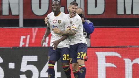Lecce's Khouma Babacar, left, celebrates after scoring his side's goal with Lecce's Marco Calderoni during a Serie A soccer match between AC Milan and Lecce, at the San Siro stadium in Milan, Italy, Sunday, Oct.20, 2019. (AP Photo/Luca Bruno)