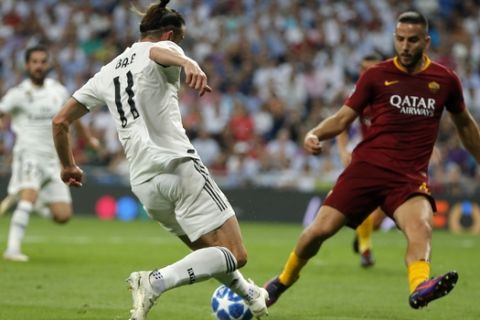 Real midfielder Gareth Bale, right, vies the ball past Roma defender Kostas Manolas during a Group G Champions League soccer match between Real Madrid and Roma at the Santiago Bernabeu stadium in Madrid, Spain, Wednesday Sept. 19, 2018. (AP Photo/Paul White)