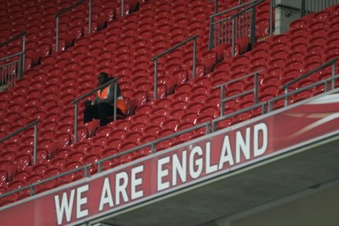 A lone steward sits in a bank of empty seats as England play the Czech Republic in an international friendly soccer match at Wembley stadium in London, Wednesday, Aug. 20, 2008. (AP Photo/Alastair Grant)