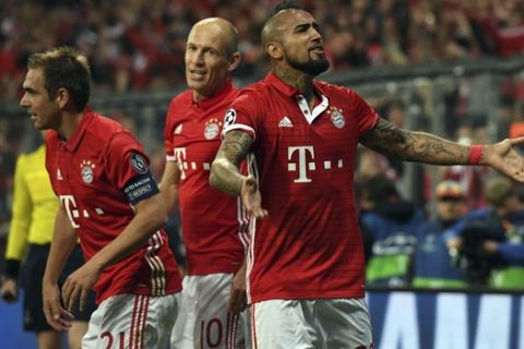 Munich's scorer Arturo Vidal, right, and his teammates Arjen Robben, center, and Philipp Lahm, left, celebrate the opening goal during the Champions League quarterfinal first leg soccer match between FC Bayern Munich and Real Madrid, in Munich, Germany, Wednesday, April 12, 2017. (Matthias Balk/dpa via AP)