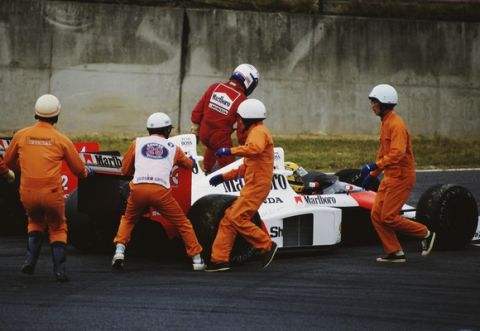 Alain Prost climbs from the #2 Marlboro McLaren-Honda MP4/5 after controversially colliding with his team mate Ayrton Senna during the Japanese Grand Prix on 22nd October 1989 at the Suzuka Circuit in Suzuka, Japan.  (Photo by Pascal Rondeau/Getty Images)