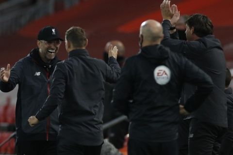 Liverpool's manager Jurgen Klopp, left turns and celebrates with his coaching staff after Liverpool's Roberto Firmino scored his sides 4th goal during the English Premier League soccer match between Liverpool and Chelsea at Anfield Stadium in Liverpool, England, Wednesday, July 22, 2020. (Phil Noble/Pool via AP)