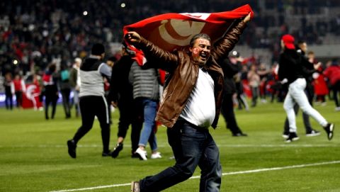 A Tunisian supporter shows the Tunisian flag on the pitch after a friendly soccer match between Tunisia and Costa Rica at the Allianz Riviera stadium in Nice, southern France, Tuesday, March 27, 2018. Tunisia won 1-0. (AP Photo/Claude Paris)