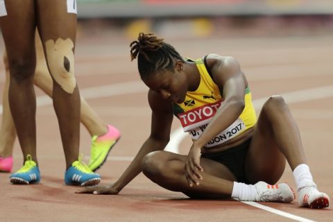 Jamaica's Danielle Williams sits on track after winning her women's 100-meter hurdles semifinal heat during the World Athletics Championships in London Friday, Aug. 11, 2017. (AP Photo/Tim Ireland)