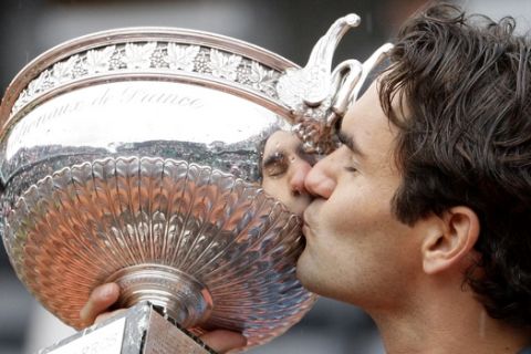 Switzerland's Roger Federer kisses the trophy after defeating Sweden's Robin Soderling during their men's singles final match of the French Open tennis tournament at the Roland Garros stadium in Paris, Sunday June 7, 2009. The victory gives Federer 14 Grand Slams, tying his career wins to American Pete Sampras. (AP Photo/Bernat Armangue)