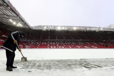 Ground Staff remove snow on the pitch before the Emirates FA Cup, quarter final soccer match between Manchester United and Brighton at Old Trafford, Manchester, England, Saturday, March 17, 2018. (Martin Rickett/PA via AP)