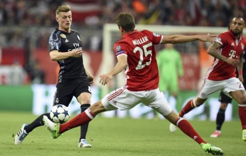 Madrid's Toni Kroos, left, and Munich's Thomas Mueller, front, cahllenge for the ball during the Champions League quarterfinal first leg soccer match between FC Bayern Munich and Real Madrid, in Munich, Germany, Wednesday, April 12, 2017. (Andreas Gebert/dpa via AP)