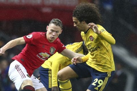 Manchester United's Scott McTominay, left, vies for the ball with Arsenal's Matteo Guendouzi during the English Premier League soccer match between Manchester United and Arsenal at Old Trafford in Manchester, England, Monday, Sept. 30, 2019. (AP Photo/Dave Thompson)