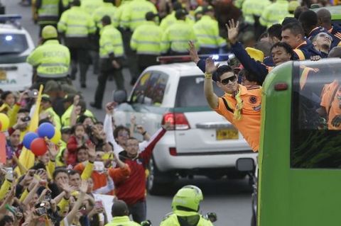 Colombia's soccer player James Rodriguez waves to supporters as he and his teammates are welcomed home from the World Cup, in Bogota, Colombia, Sunday, July 6, 2014. Thousands of fans turned out for the Sunday homecoming of Rodriguez, his teammates and coach Jose Pekerman following their 2-1 loss to Brazil in the quarterfinals on Friday. (AP Photo/Fernando Vergara) Colombia Brazil WCup Homecoming