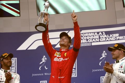 Ferrari driver Charles Leclerc of Monaco, center, lifts the trophy after finishing first in the Belgian Formula One Grand Prix in Spa-Francorchamps, Belgium, Sunday, Sept. 1, 2019. Mercedes driver Lewis Hamilton of Britain, left, placed second and Mercedes driver Valtteri Bottas of Finland, right, placed third. (AP Photo/Francisco Seco)
