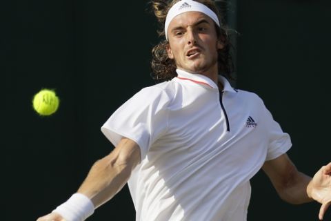 Stefanos Tsitsipas of Greece returns a ball to Thomas Fabbiano of Italy during their men's singles match on the fifth day at the Wimbledon Tennis Championships in London, Friday July 6, 2018. (AP Photo/Kirsty Wigglesworth)
