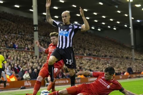 Newcastle United's Gabriel Obertan, center, evades a tackle by Liverpool's Dejan Lovren, right, as Alberto Moreno looks on during the English Premier League soccer match between Liverpool and Newcastle at Anfield Stadium, Liverpool, England, Monday, April 13, 2015. (AP Photo/Jon Super)