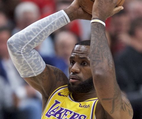 Los Angeles Lakers forward LeBron James, right, looks to pass around Portland Trail Blazers forward Al-Farouq Aminu during the first half of an NBA basketball game in Portland, Ore., Thursday, Oct. 18, 2018. (AP Photo/Craig Mitchelldyer)