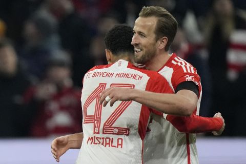 Bayern's Harry Kane, right, celebrates with team mate Jamal Musiala after scoring his side's opening goal during the German Bundesliga soccer match between FC Bayern Munich and RB Leipzig at the Allianz Arena in Munich, Germany, Feb. 24, 2024. (AP Photo/Matthias Schrader)