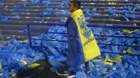 A fan of Boca Juniors wear his team's flag after a Copa Libertadores semifinal second leg soccer match against River Plate at La Bombonera stadium in Buenos Aires, Argentina, Wednesday, Oct. 23, 2019. Boca Juniors won the match 1-0 but lost on aggregate and River Plate qualified to the final. (AP Photo/Natacha Pisarenko)