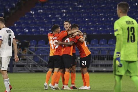 Shakhtar' players celebrate the third goal of their team during the Europa League quarter-final soccer match between Shakhtar Donetsk and FC Basel at the Veltins-Arena in Gelsenkirchen, Germany, Tuesday, Aug. 11, 2020. (Lars Baron/Pool via AP)