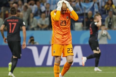 Argentina goalkeeper Wilfredo Caballero holds his head after Croatia's Ante Rebic, background right, scored the opening goal during the group D match between Argentina and Croatia at the 2018 soccer World Cup in Nizhny Novgorod Stadium in Nizhny Novgorod, Russia, Thursday, June 21, 2018. (AP Photo/Ricardo Mazalan)