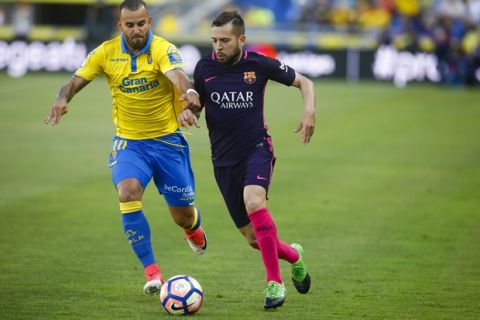 FC Barcelona's Jordi Alba, duels for the ball against Las Palma's Jese during a Spanish La Liga soccer match at the Gran Canaria stadium in Las Palmas, Spain's Canary islands, Sunday May 14, 2017. (AP Photo/Lucas de Leon)