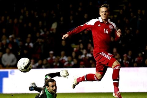 Denmark's Nicki Bille Nielsen, right, scores a goal past Malta's Justin Haber to bring the score to 6-0, during their Group B 2014  World Cup qualifying soccer match played in Parken, Copenhagen on Tuesday, Oct 15, 2013. (AP Photo / POLFOTO, Jens Dresling) DENMARK OUT