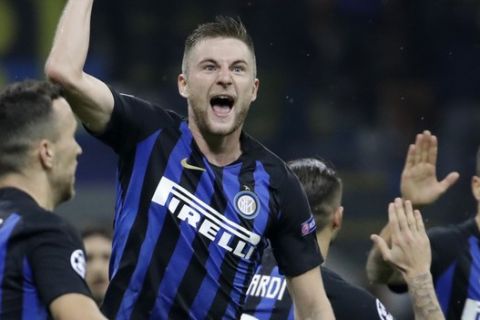 Inter defender Milan Skriniar, center, celebrates after his teammate Inter forward Mauro Icardi, scored his side's opening goal during the Champions League group B soccer match between Inter Milan and Barcelona at the San Siro stadium in Milan, Italy, Tuesday, Nov. 6, 2018. (AP Photo/Luca Bruno)