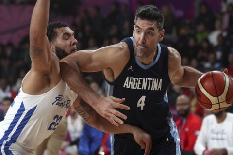 Luis Scola of Argentina, right, pressures Emmanuel Andujar of Puerto Rico, during the men's basketball final match at the Pan American Games in Lima, Peru, Sunday, Aug. 4, 2019. (AP Photo/Martin Mejia)