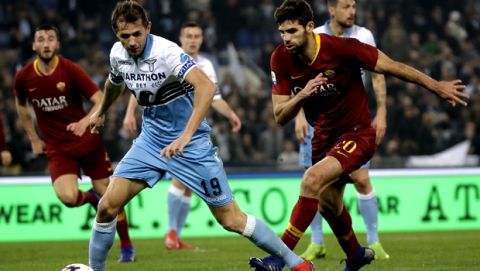 Lazio's Senad Lulic, left, and Roma's Federico Fazio challenge for the ball during a Serie A soccer match between Lazio and Roma at Rome's Olympic stadium, Saturday, March 2, 2019. (AP Photo/Alessandra Tarantino)