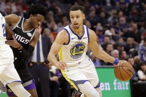 Sacramento Kings guard De'Aaron Fox, left, tries to fight through a screen as he guards against Golden State Warriors guard Stephen Curry, right, during the first half of an NBA basketball game Friday, Dec. 14, 2018, in Sacramento, Calif. (AP Photo/Rich Pedroncelli)