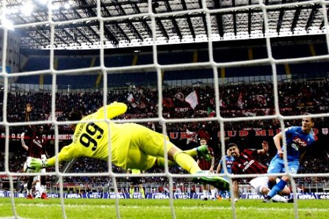 AC Milan goalkeeper Gianluigi Donnarumma, left, dives to save a kick by Napoli's Arkadiusz Milik during the Serie A soccer match between AC Milan and Napoli at the San Siro stadium in Milan, Italy, Sunday, April 15, 2018. Rossoneri goalkeeper Gianluigi Donnarumma made history as the youngest ever player to reach 100 Serie A appearances, aged just 19 years, one month and 21 days and he proved decisive in denying Napoli a last-gasp winner. The match need in a goalless draw. (AP Photo/Antonio Calanni)
