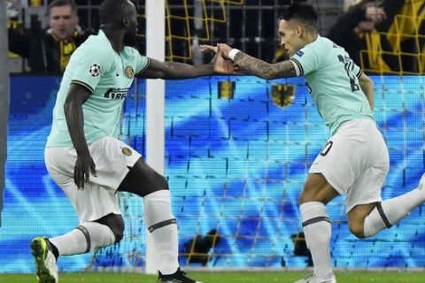 Inter Milan's Lautaro Martinez, center, celebrates with his teammates Romelu Lukaku, left, and Nicolo Barella after scoring his side's opening goal during the Champions League group F soccer match between Borussia Dortmund and Inter Milan, in Dortmund, Germany, Tuesday, Nov. 5, 2019. (AP Photo/Martin Meissner)