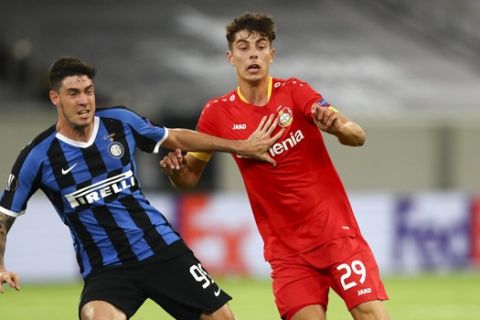 Inter Milan's Alessandro Bastoni, left, and Leverkusen's Kai Havertz battle for the ball during the Europa League quarterfinal match between Inter Milan and Bayer Leverkusen at the Duesseldorf Arena in Dusseldorf, Germany, Monday, Aug. 10, 2020. (Dean Mouhtaropoulos, Pool Photo via AP)