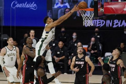 Milwaukee Bucks' Giannis Antetokounmpo (34) dunks in front of Miami Heat's Goran Dragic (7) in the second half of an NBA conference semifinal playoff basketball game, Friday, Sept. 4, 2020, in Lake Buena Vista, Fla. (AP Photo/Mark J. Terrill)
