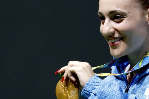 Anna Korakaki of Greece displays her gold medal following the victory ceremony for the women's 25-meter pistol event at the Olympic Shooting Center at the 2016 Summer Olympics in Rio de Janeiro, Brazil, Tuesday, Aug. 9, 2016. (AP Photo/Hassan Ammar)