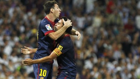 FC Barcelona's Lionel Messi from Argentina, left, celebrates his goal with Xavi Hernandez, right, during a Spanish Supercup second leg soccer match against Real Madrid at the Santiago Bernabeu stadium in Madrid, Spain, Wednesday, Aug. 29, 2012. (AP Photo/Andres Kudacki)