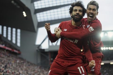 Liverpool's Mohamed Salah, left, and Liverpool's Roberto Firmino celebrate after Tottenham's Toby Alderweireld scores an own goal past his goalkeeper during the English Premier League soccer match between Liverpool and Tottenham Hotspur at Anfield stadium in Liverpool, England, Sunday, March 31, 2019. (AP Photo/Rui Vieira)