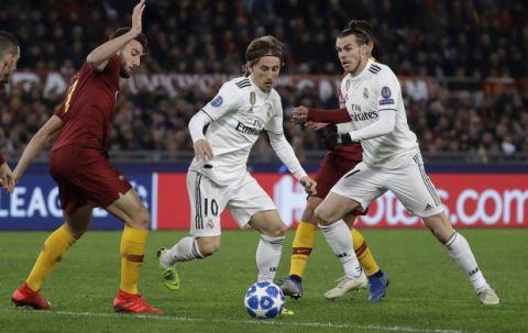 Real midfielder Luka Modric, center, runs with the ball between Real midfielder Gareth Bale, right, and Roma defender Kostas Manolas during a Champions League, Group G soccer match between Roma and Real Madrid at the Rome Olympic stadium, Tuesday, Nov. 27, 2018. (AP Photo/Andrew Medichini)